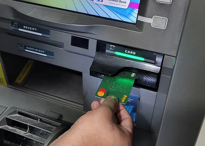 Person withdrawing money from ATM with Priyo card